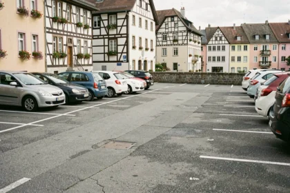 Parking à ciel ouvert en centre-ville de Colmar avec les maisons alsaciennes à colombages de la Petite Venise en arrière-plan